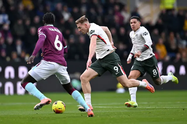 BURNLEY, ENGLAND - NOVEMBER 22: Liam Delap of Chelsea is challenged by Axel Tuanzebe of Burnley during the Premier League match between Burnley and Chelsea at Turf Moor on November 22, 2025 in Burnley, England