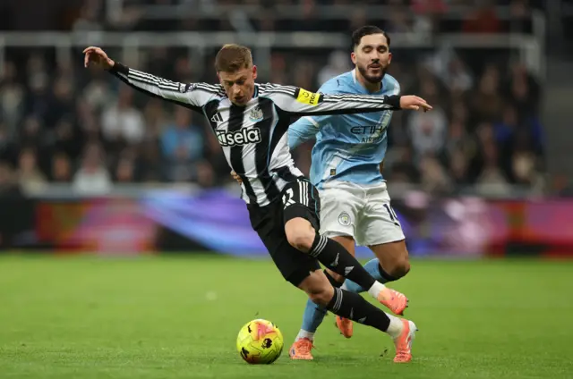 Newcastle United's Harvey Barnes in action with Manchester City's Rayan Cherki