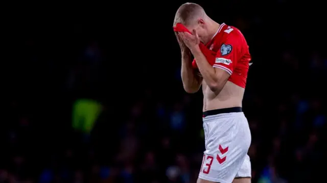 Denmark's Rasmus Kristensen looks dejected after receiving a red card during a FIFA World Cup 2026 Qualifier