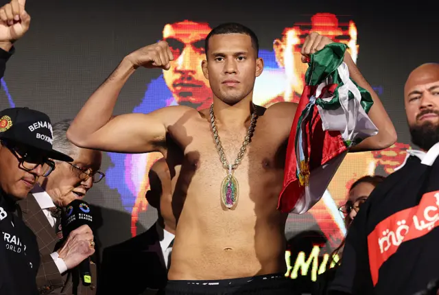 David Benavidez holds up his arms as he stands on scales