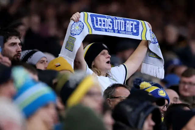 Leeds United fan shows her support by holding up a scarf prior to the Premier League match between Leeds United and Aston Villa at Elland Road on November 23, 2025 in Leeds, England.