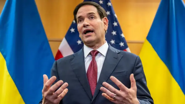US Secretary of state Marco Rubio, talks to the press with a background of flags