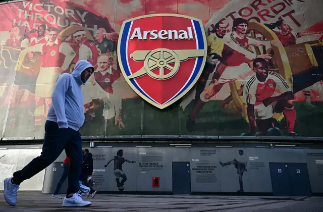 Arsenal sign with fan walking past