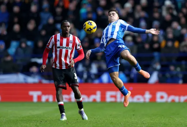 Harry Amass of Sheffield Wednesday controls the ball whilst under pressure from Sam McCallum of Sheffield United
