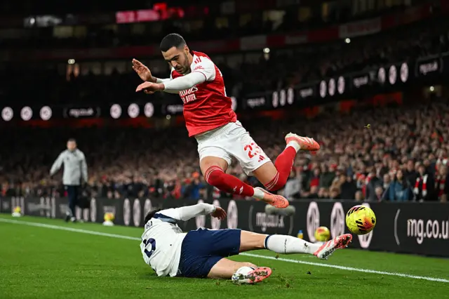 Mikel Merino of Arsenal is tackled by Joao Palhinha of Tottenham Hotspur during the Premier League match between Arsenal and Tottenham Hotspur at Emirates Stadium on November 23, 2025 in London, England.