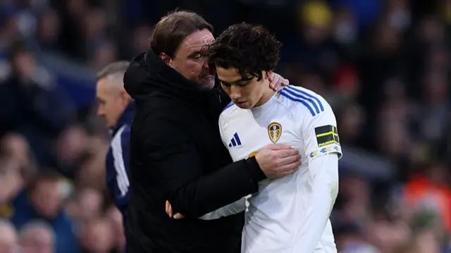 Daniel Farke, Manager of Leeds United, speaks with Ao Tanaka of Leeds United after being substituted off during the Premier League match between Leeds United and Aston Villa at Elland Road on November 23, 2025 in Leeds, England.