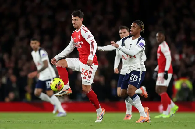 Martin Zubimendi of Arsenal controls the ball whilst under pressure from Wilson Odobert of Tottenham Hotspur during the Premier League match between Arsenal and Tottenham Hotspur at Emirates Stadium on November 23, 2025 in London, England.