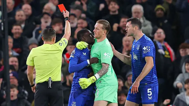 Idrissa Gueye is held back by Jordan Pickford while being shown a red card