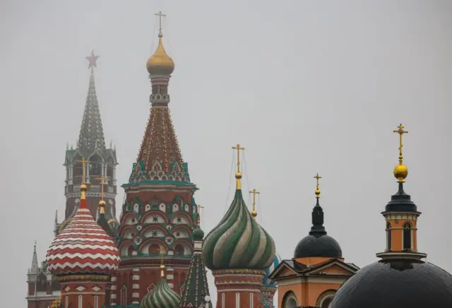 The Spaskaya tower of the Kremlin and St. Basil's Cathedral seen in the mist during rainy day in Moscow, Russia, 24 November 2025