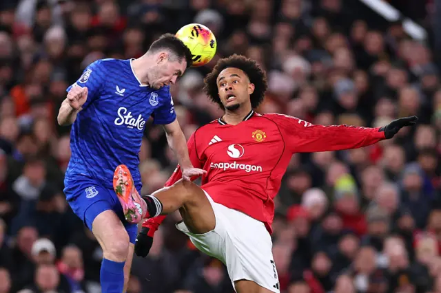 Michael Keane heads away from Joshua Zirkzee