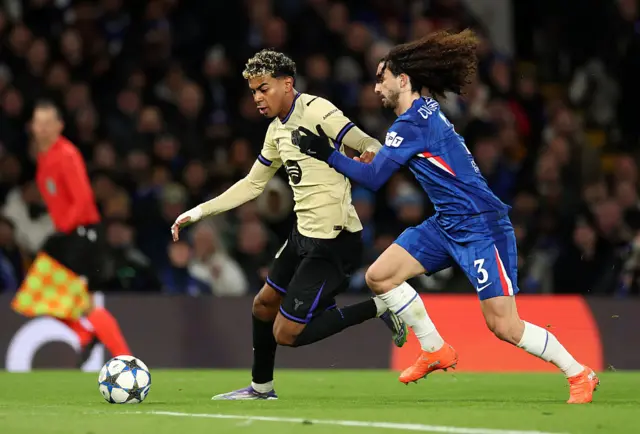 Lamine Yamal of Barcelona runs with the ball whilst under pressure from Marc Cucurella of Chelsea