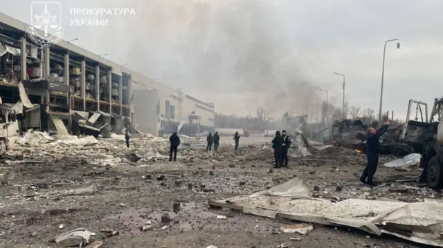 A supermarket distribution centre in Kyiv is seen surrounded by rubble and smoke after an overnight Russian attack