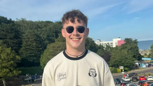 Joel looks to camera and smiles