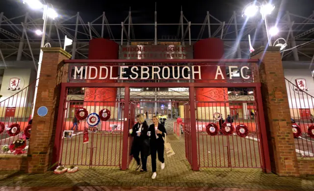 Two Middlesbrough fans walk through the gates outside the Riverside