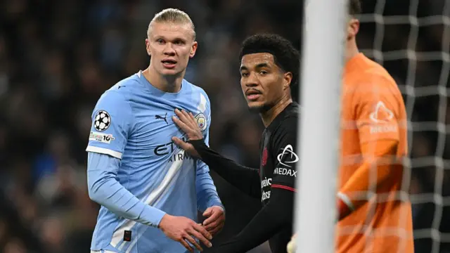 Erling Haaland (L) marked by Bayer Leverkusen midfielder Malik Tillman (C)