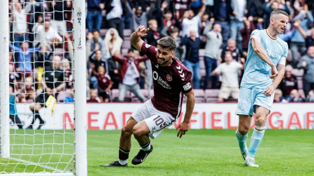 Claudio Braga celebrates as Paul McGinn reacts furiously to Hearts' equaliser