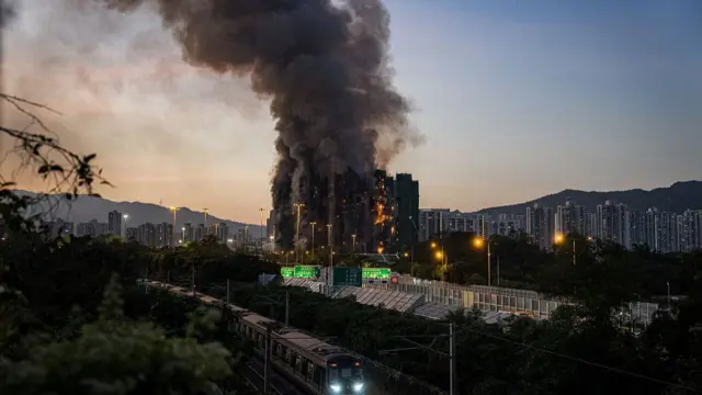 Thick smoke and flames rise as a major fire engulfs several apartment blocks at the Wang Fuk Court residential estate in Hong Kong's Tai Po district on November 26, 2025