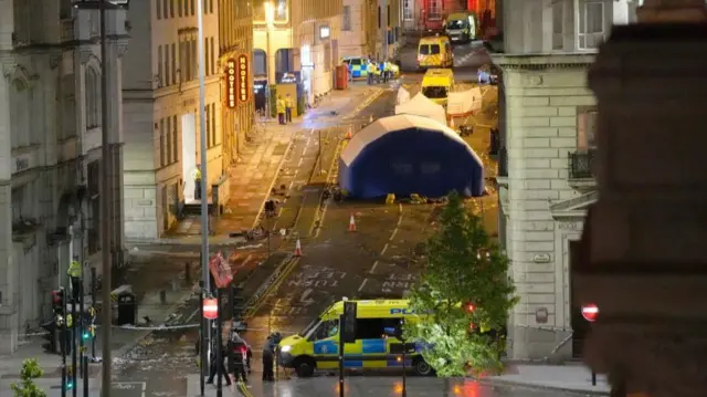 The aftermath of Water Street in Liverpool where paul Doyle drove a car at a crowd. There is a forensics tent in place and several ambulances parked up, as well as a police cordon.