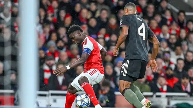 Bukayo Saka of Arsenal and Jonathan Tah of Bayern Munich battle for the ball