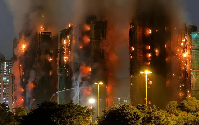 Blazing apartment towers in Hong Kong billow smoke and fire.