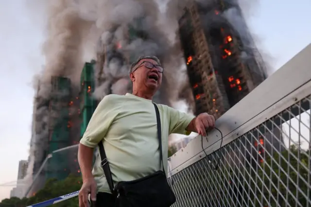Man in anguish outside burning buildings