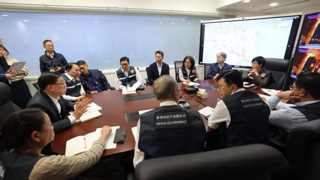 John Lee Ka-chiu, Hong Kong's chief executive, sits at a conference table with government officials during an emergency meeting.