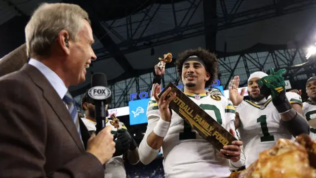 Green Bay Packers quarterback Jordan Love celebrates with the Madden MVP trophy after defeating the Detroit Lions