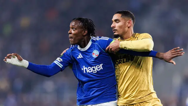 Maxence Lacroix of Crystal Palace (R) puts a tackle on Emmanuel Emegha of Strasbourg (L)