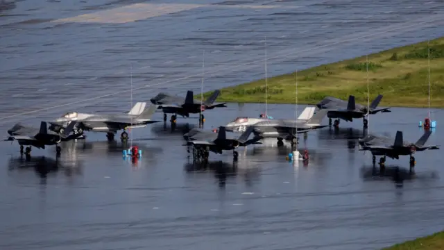 Seven F35 fighter jets parked in an airfield