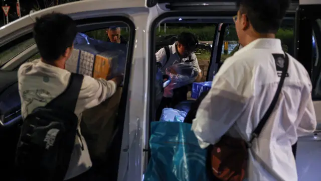 People transport supplies to the scene of the Wang Fuk Court housing estate fire