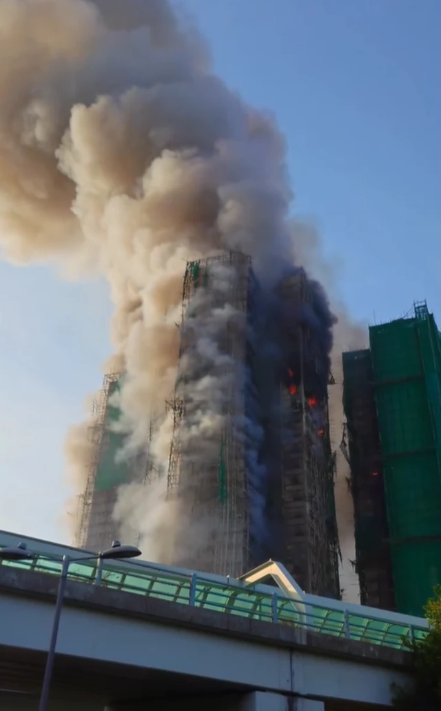A tower block on fire with a large smoke plume