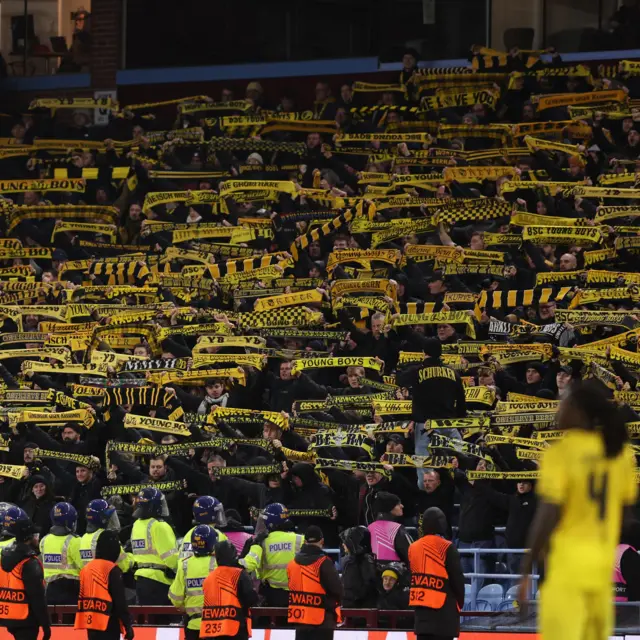 Young Boys fans hold aloft scarves in the away end