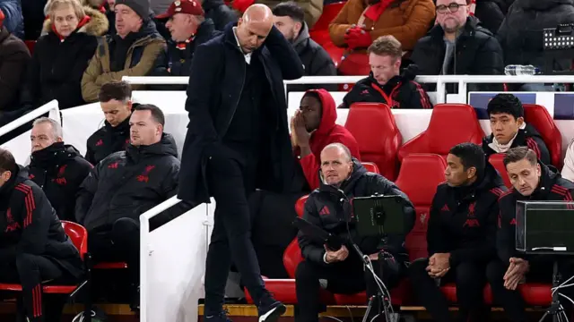Arne Slot scratches his head on the sideline during Liverpool's game against PSV.