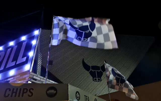 The outside of Oxford's Kassam Stadium with a flag waving