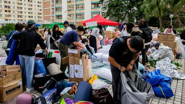 Volunteers and those impacted sort through donations of blankets and clothes