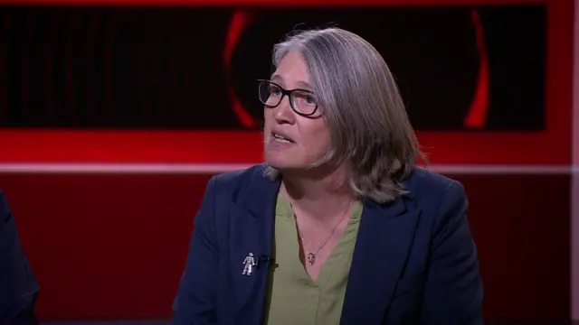 Laura Kerby, who has a shoulder-length greying bob and wears a prostate cancer brooch on her lapel, in the BBC studio