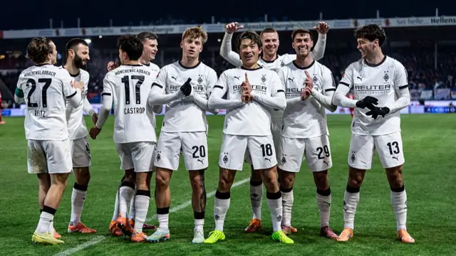 Shuto Machino of Borussia Moenchengladbach celebrate with team mates after he scores