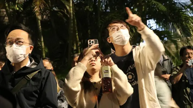 People are waiting at the site as rescue efforts continue at the Wang Fuk Court residential buildings, in Tai Po, Hong Kong, on 27 November 2025.