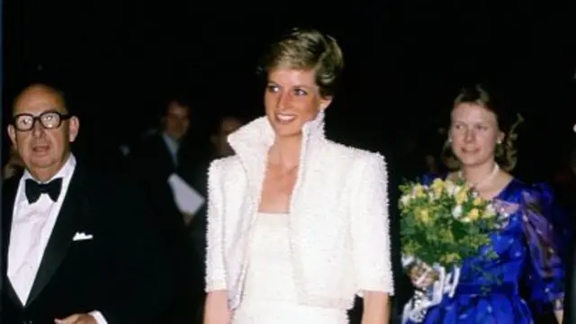 Diana in a white jacket and dress