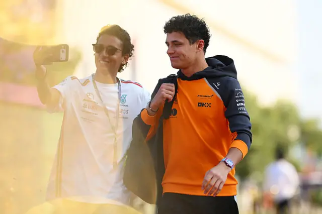 Lando Norris takes a picture with a fan in Qatar