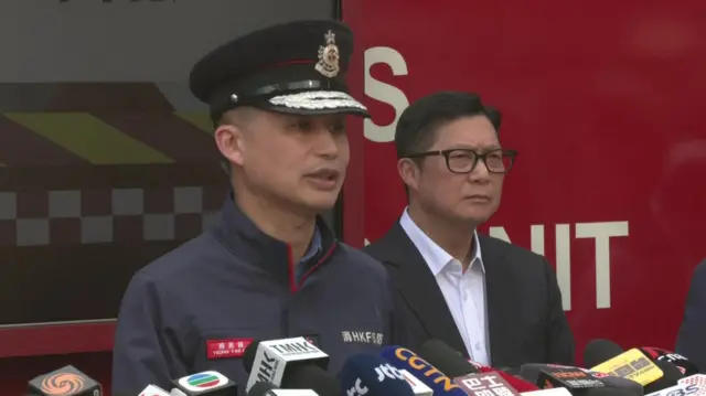 Two officials speak to a press conference following Hong Kong high-rise fire
