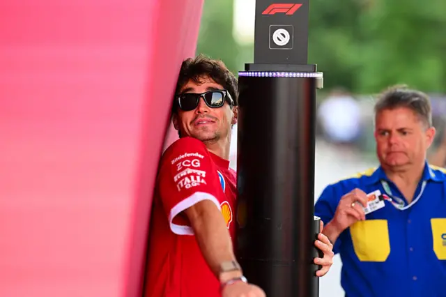 Charles Leclerc tries to squeeze past the barries to enter the paddock in Qatar