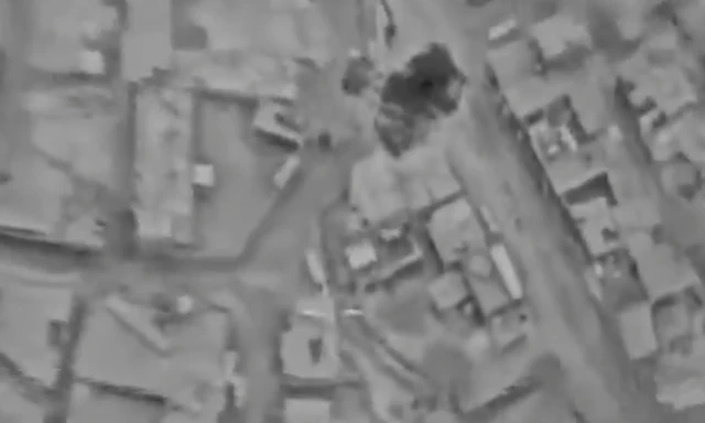 A gunsight image from the released IDF video showing the village in black and white and black smoke rising from one of the targets