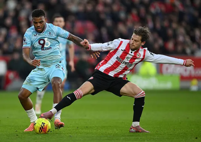 Lyle Foster of Burnley is challenged by Mathias Jensen of Brentford