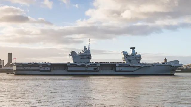 Tugs support the HMS Prince of Wales aircraft carrier on the River Mersey as she departs Liverpool, Merseyside, UK on 9 December 2024 after visiting the city for the second time.