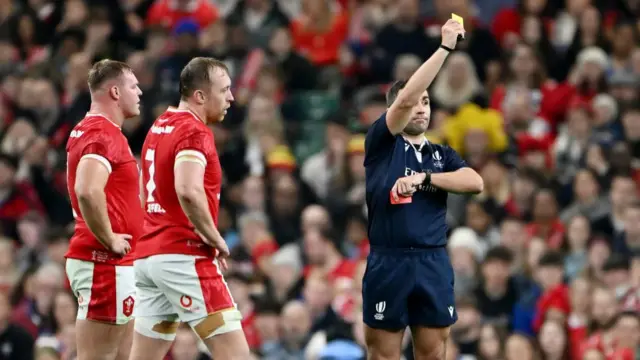 Luc Ramos shows a yellow card to Tommy Reffell