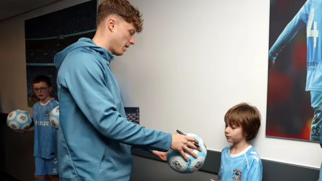 Coventry's Victor Torp signs a ball for a young fan
