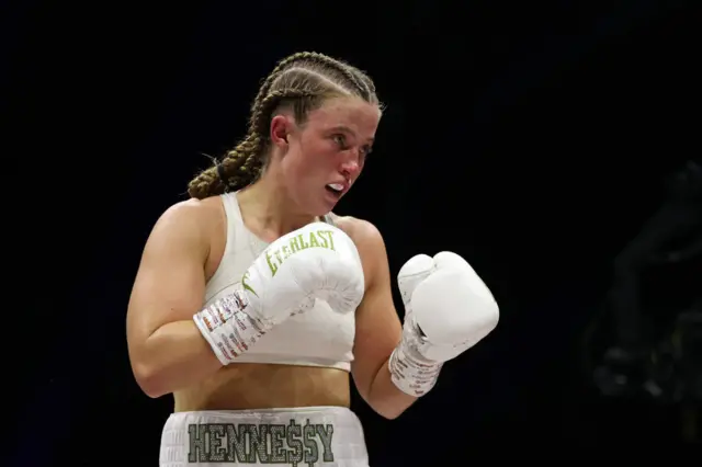 Francesca Hennessy holds up her hands and is wearing white boxing gloves