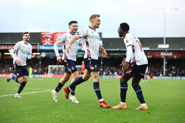 Bolton players celebrate the opening goal at Luton