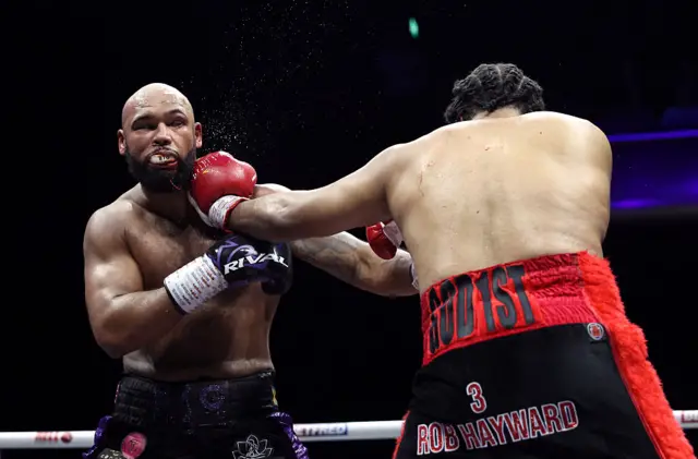 Frazer Clarke spits his mouthguard and blood as he is punched by Jeamie TKV